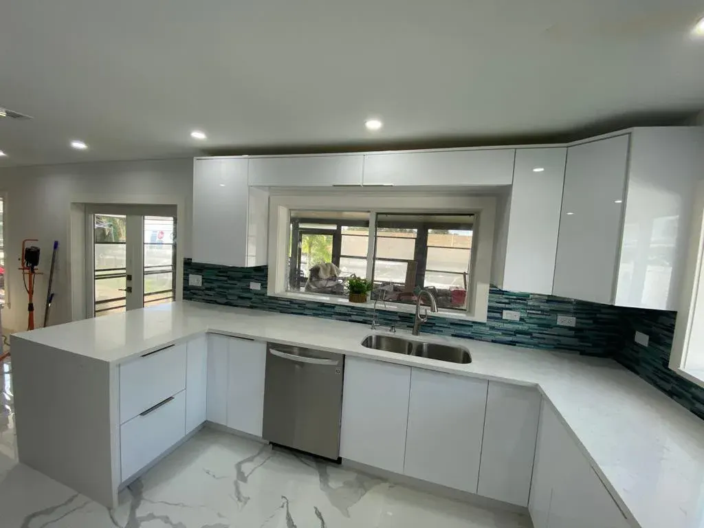White U-shaped kitchen with a glass tile backsplash