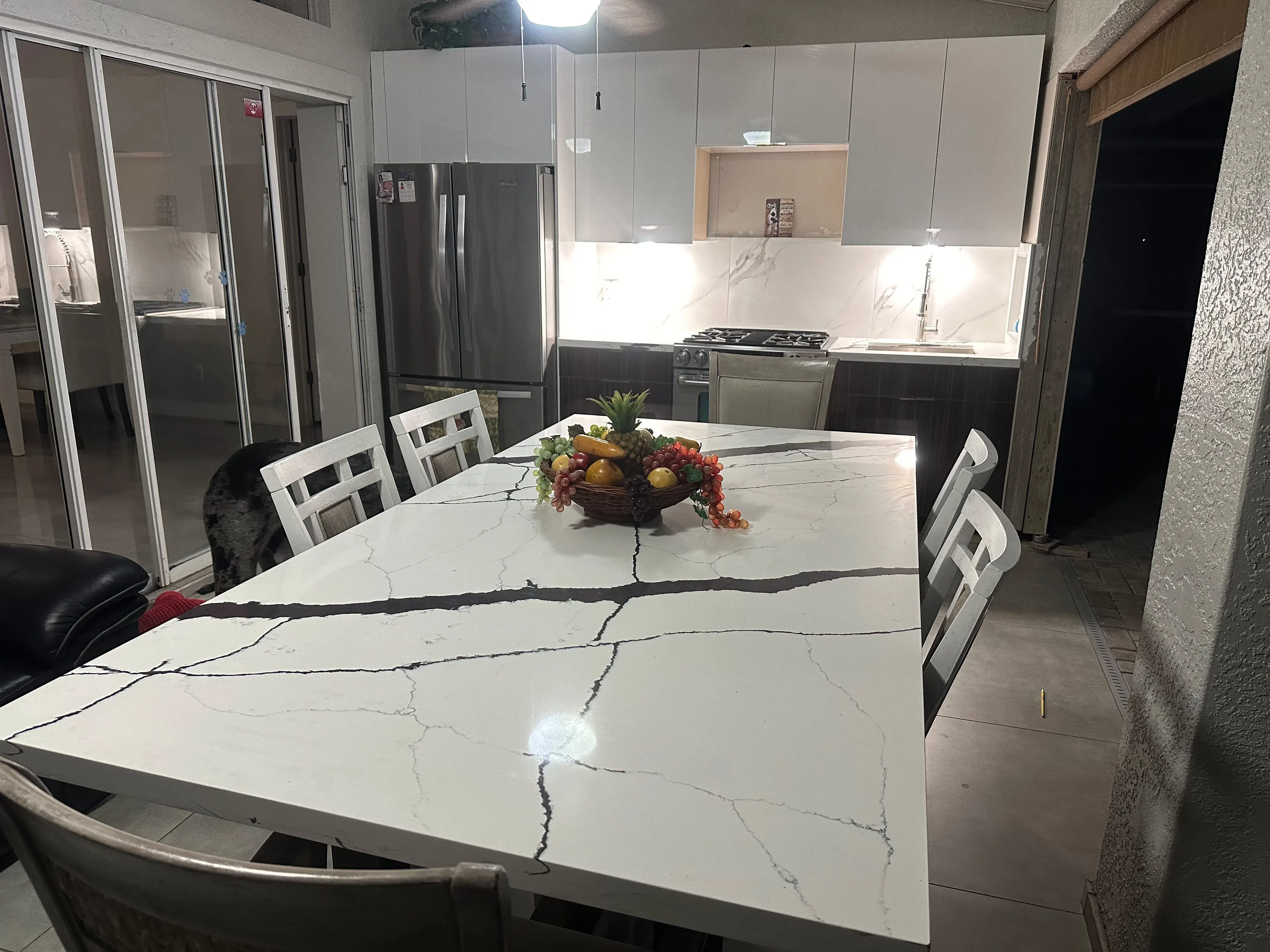 Kitchen with white cabinets and a marble dining table
