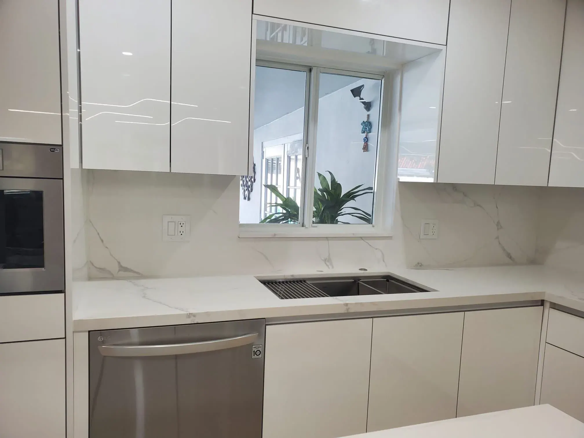 High-gloss white cabinets with a marble backsplash