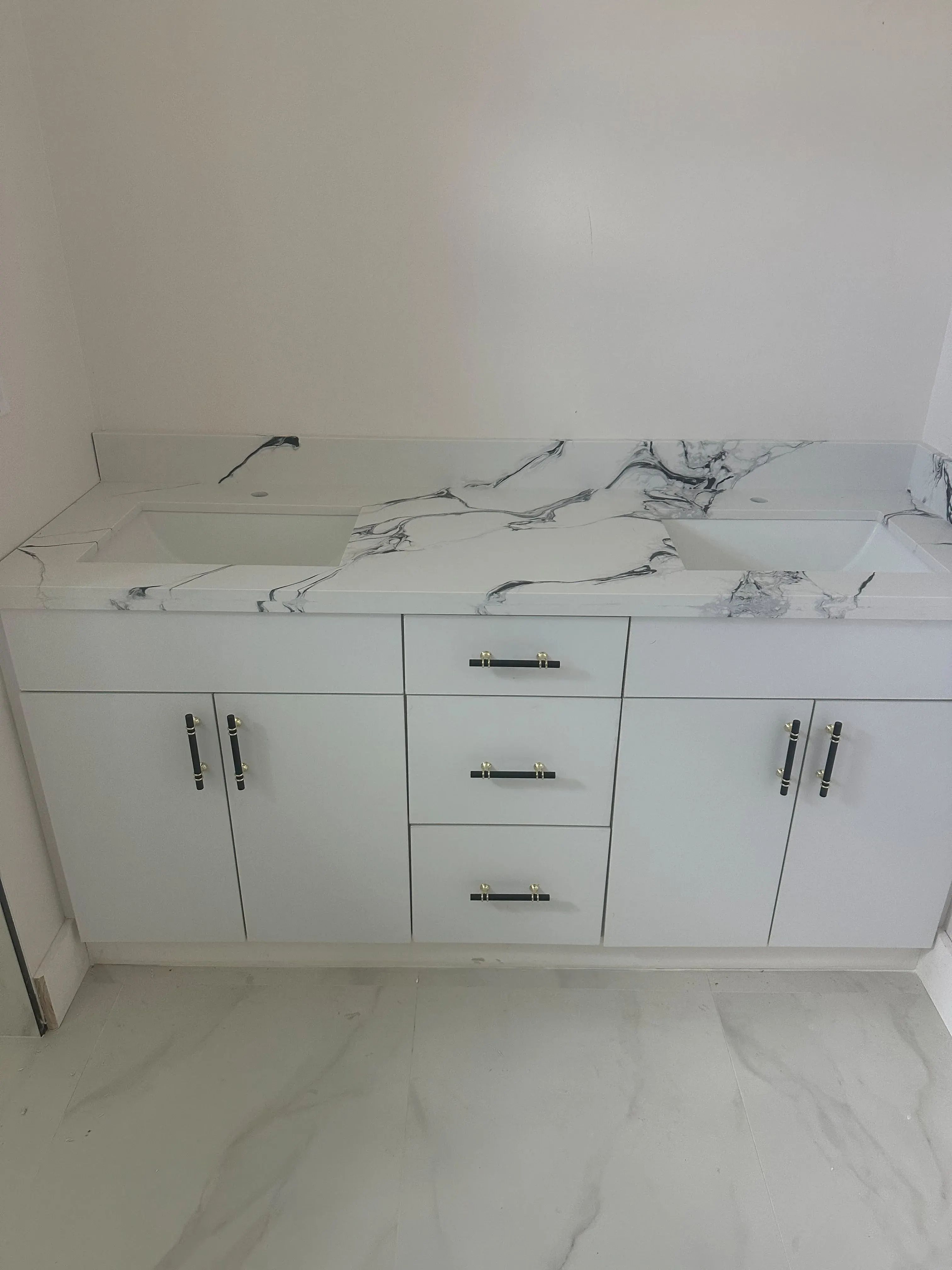 White vanity cabinet with drawers and a marble top