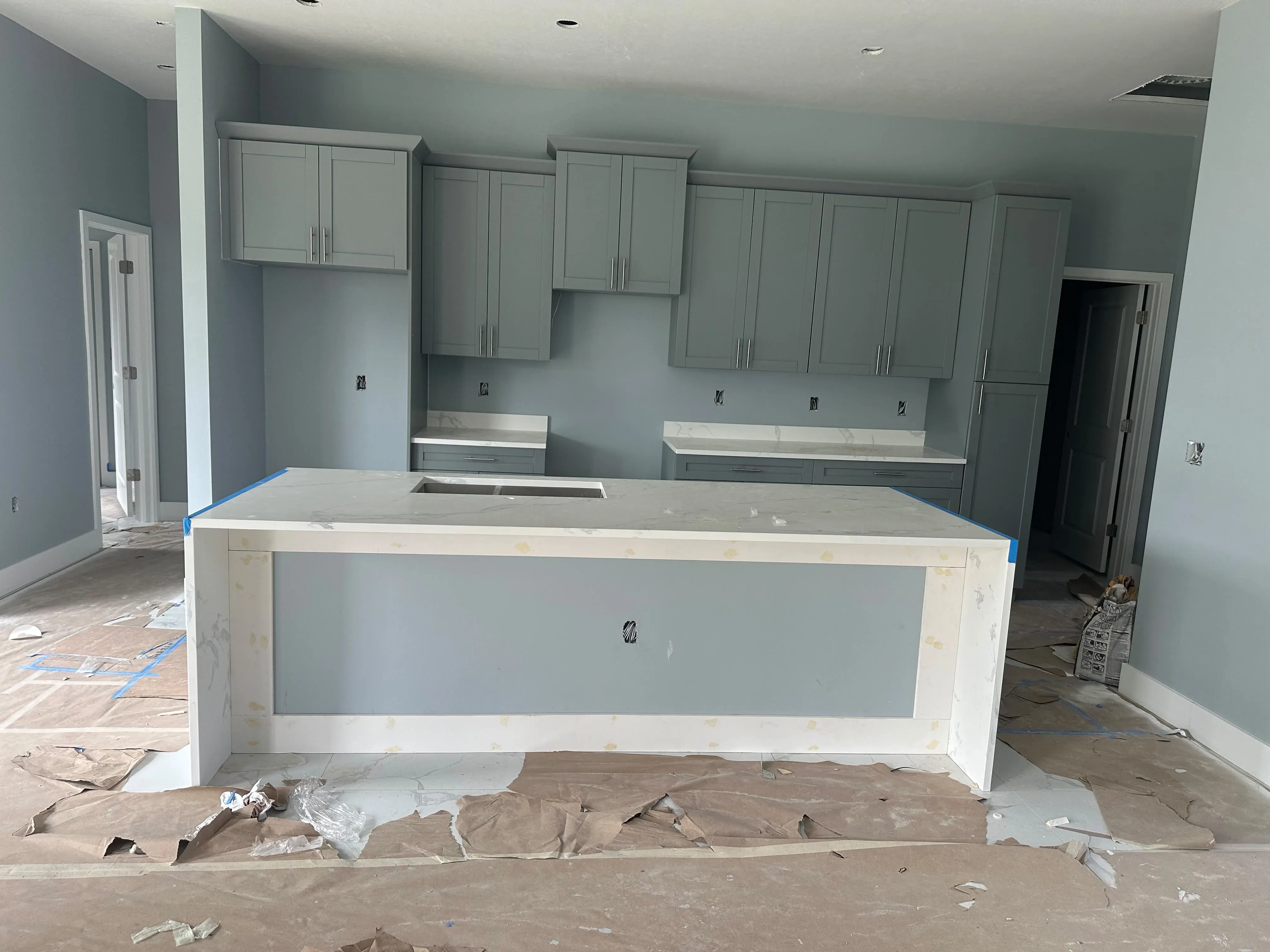 Gray shaker cabinets and island in a kitchen under construction