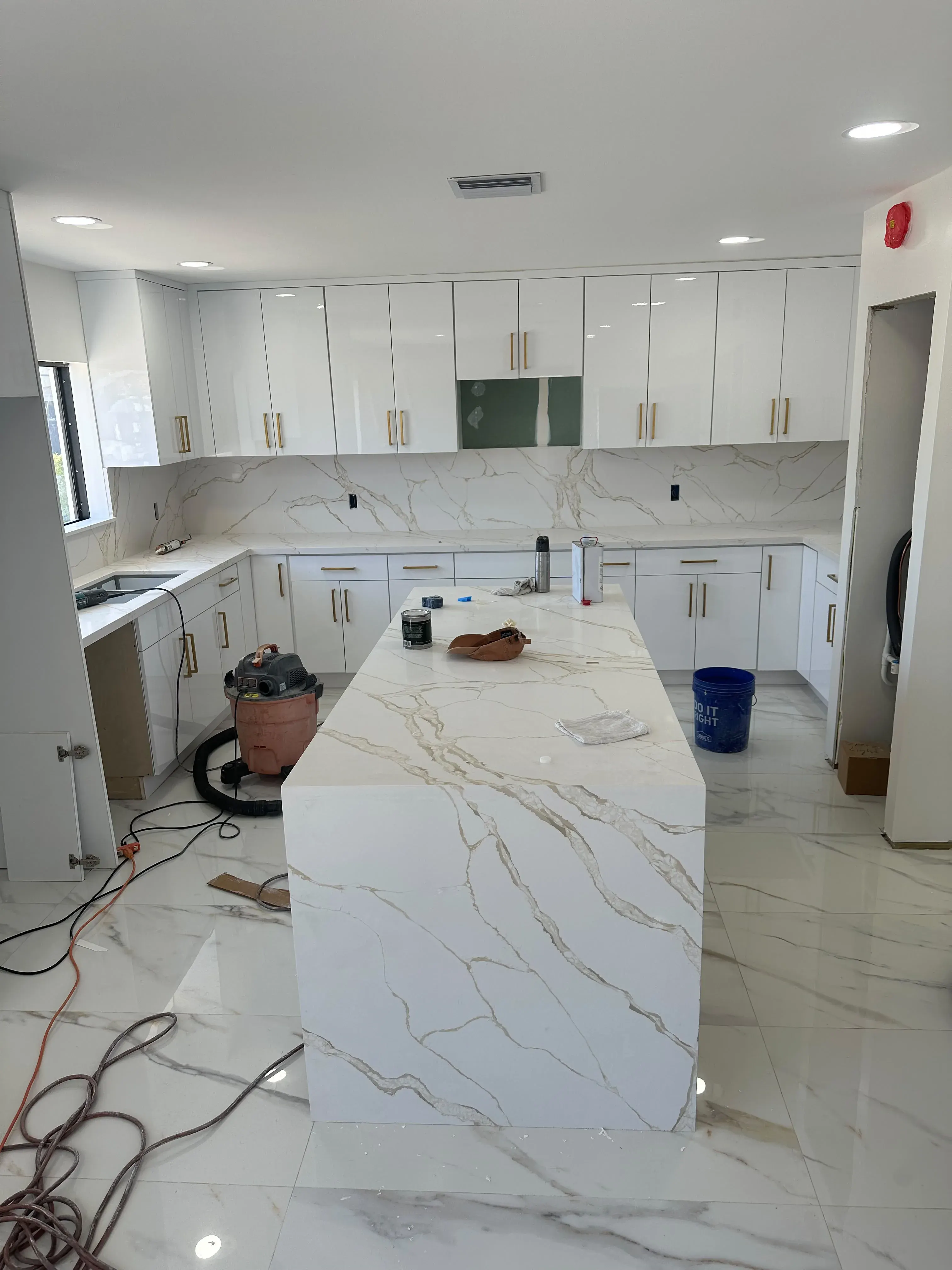 White kitchen with a marble waterfall island