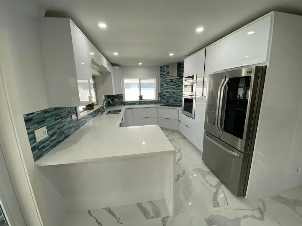 White high-gloss kitchen with a glass tile backsplash