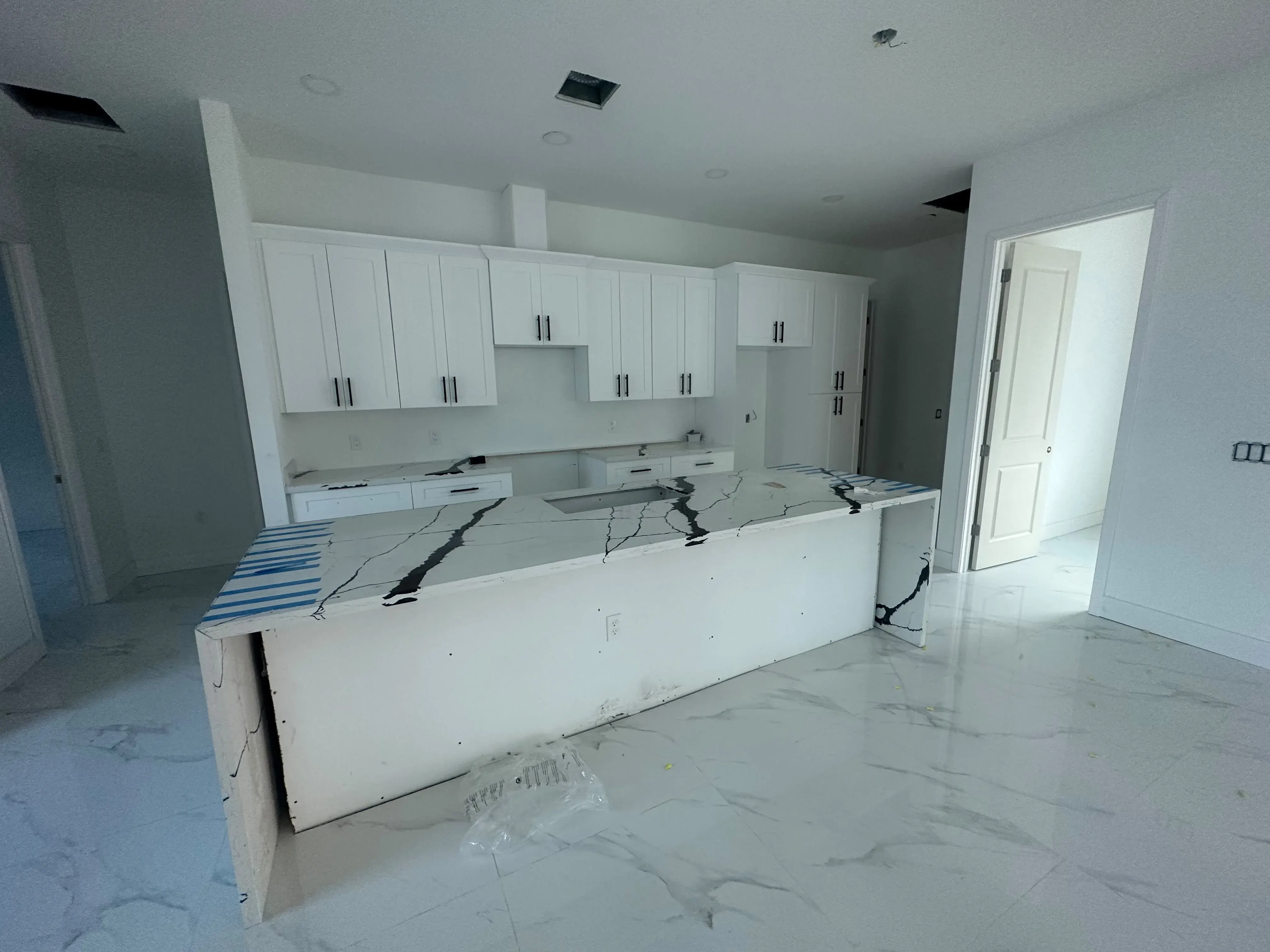 Kitchen under construction with new white cabinets and an island