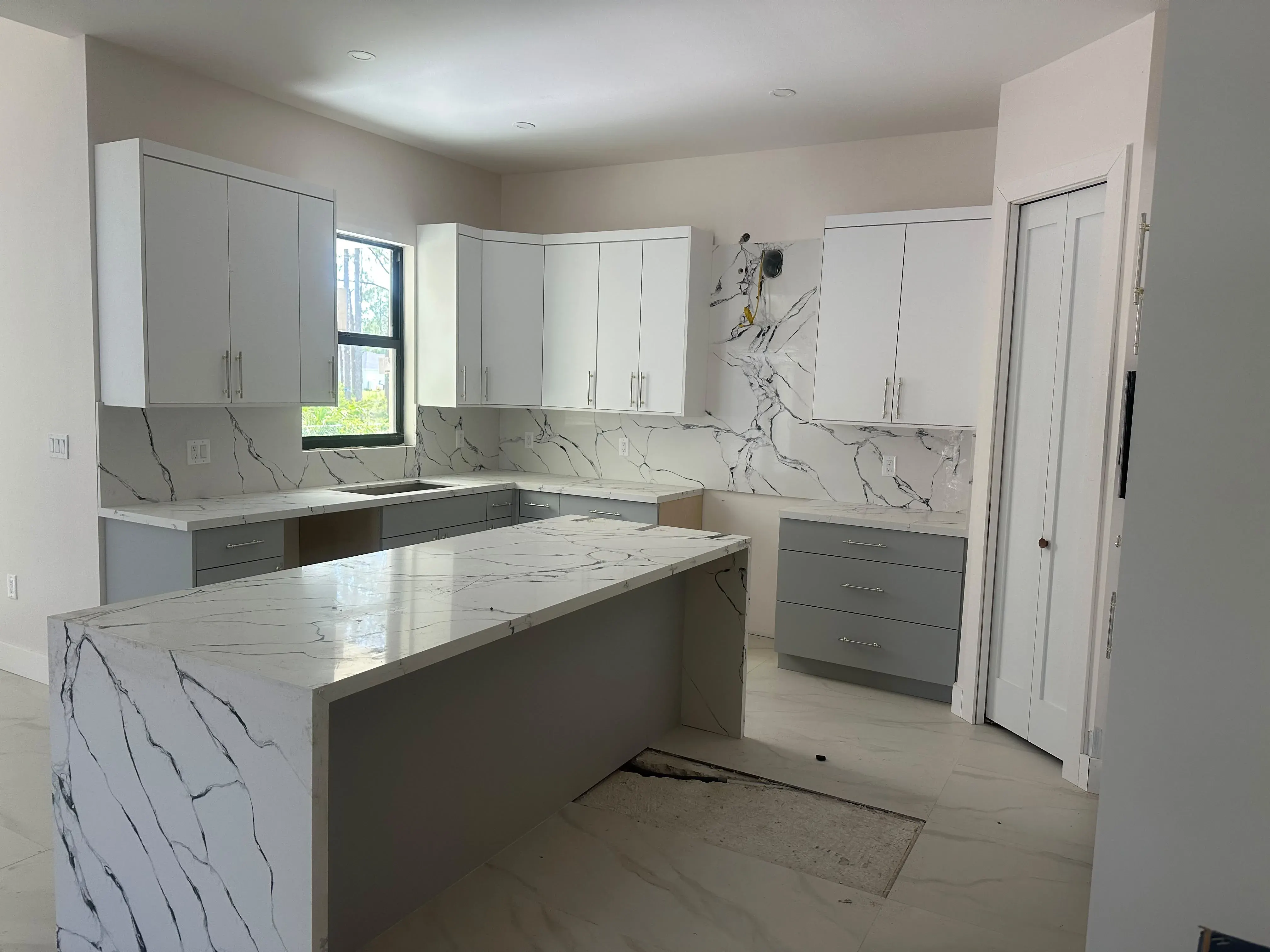 White cabinets with a marble waterfall island
