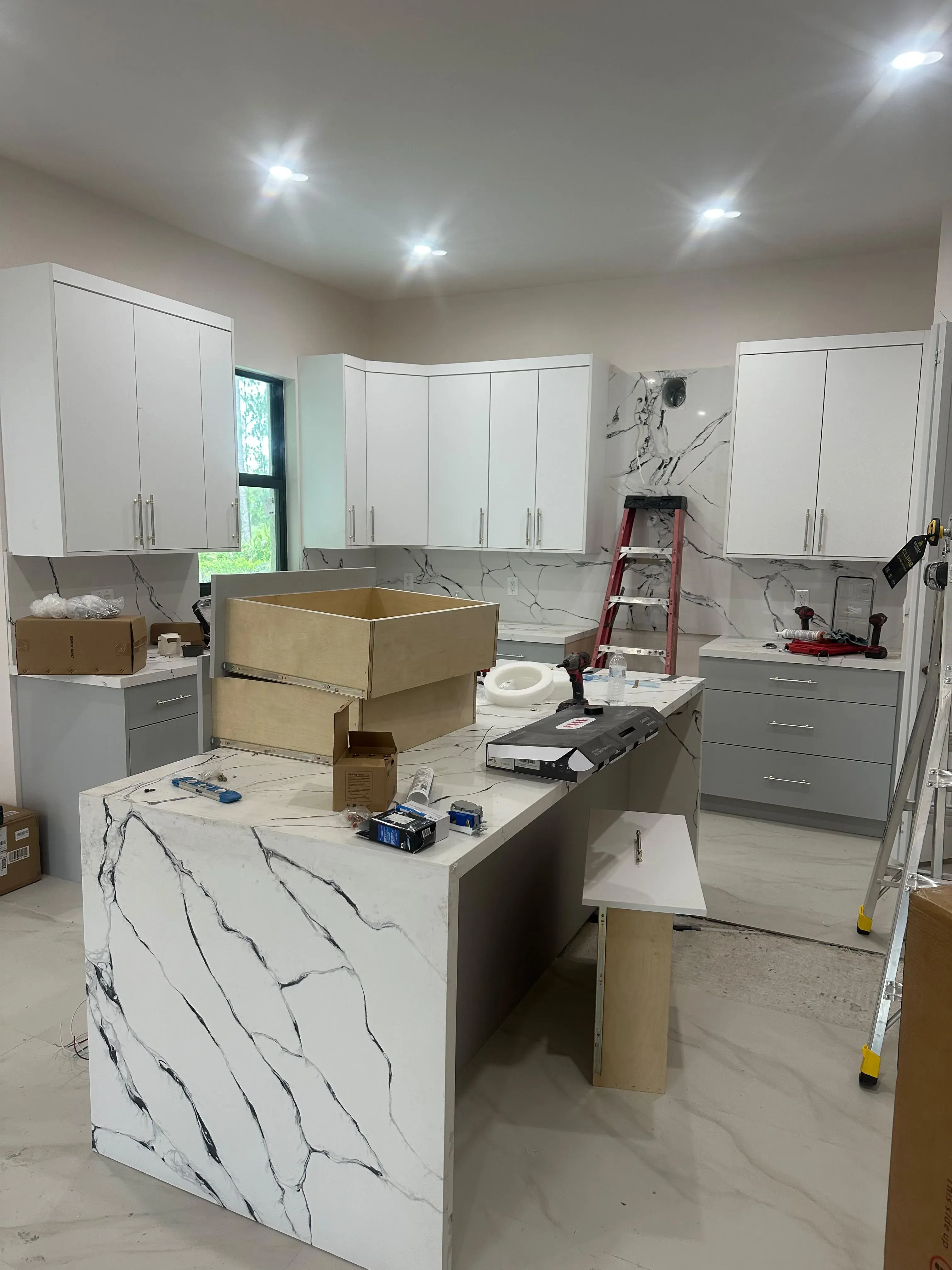 White cabinets and an island with a marble pattern