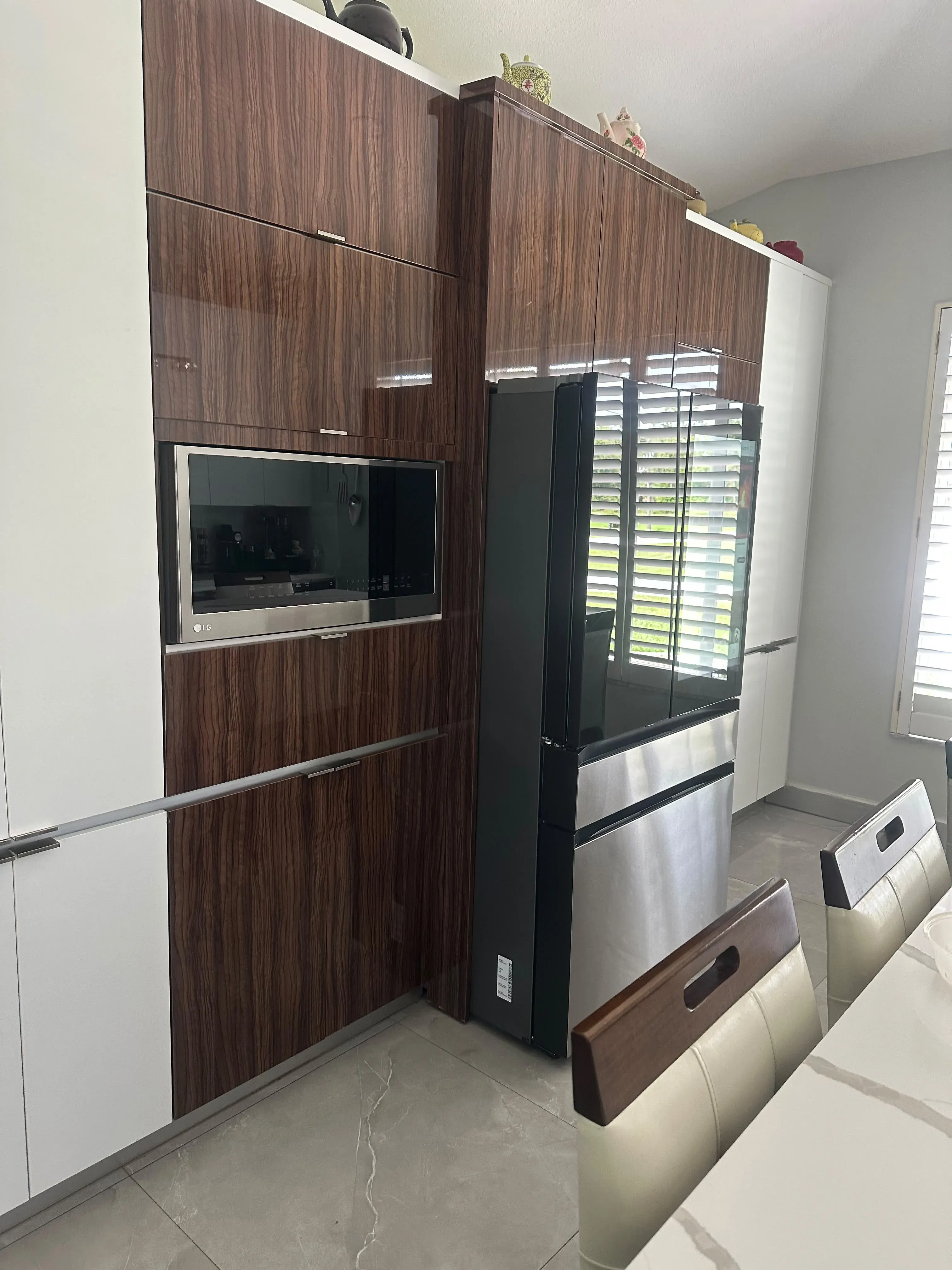 Wood-paneled tall cabinets around a refrigerator