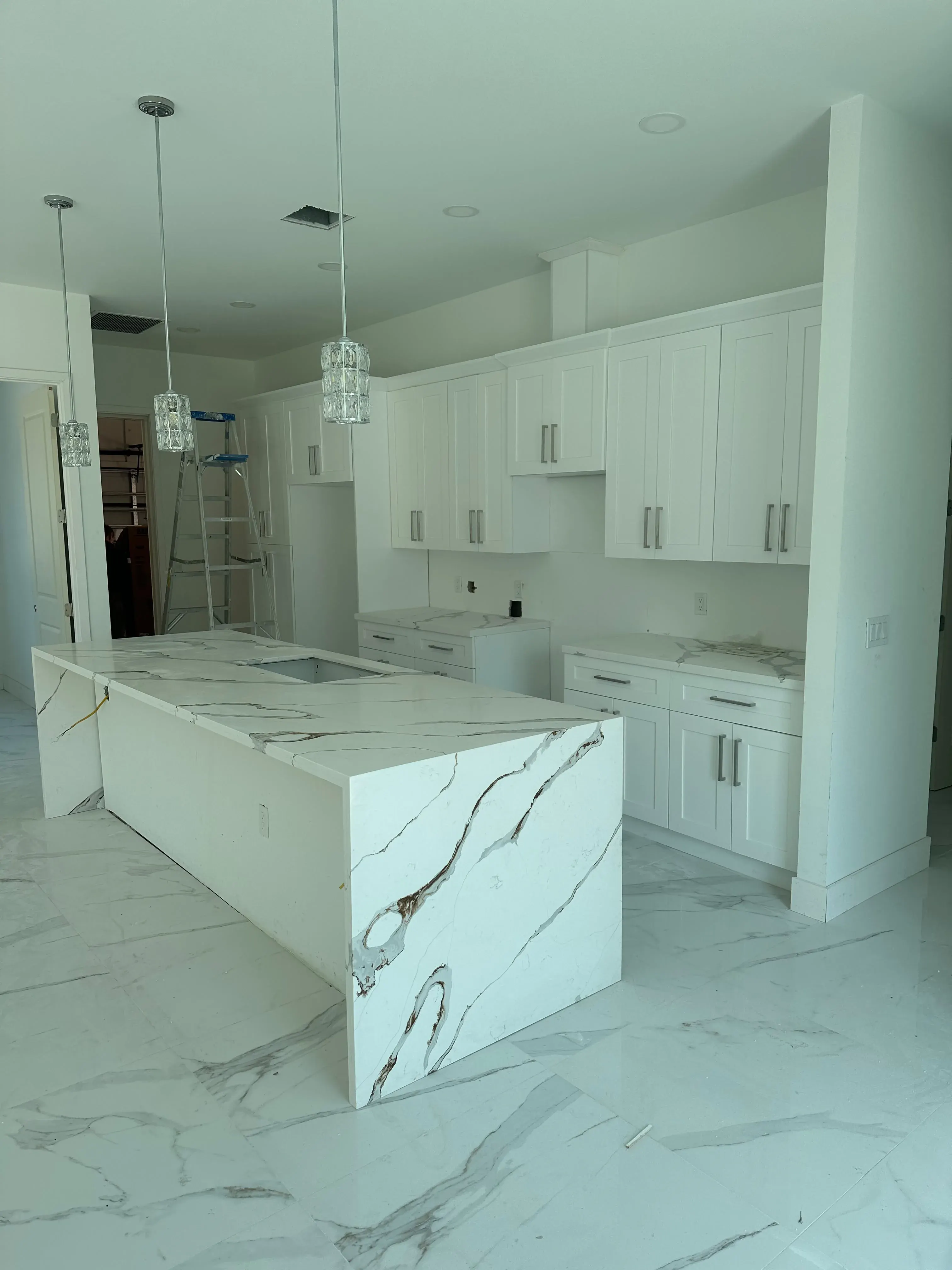 White kitchen with a large marble island