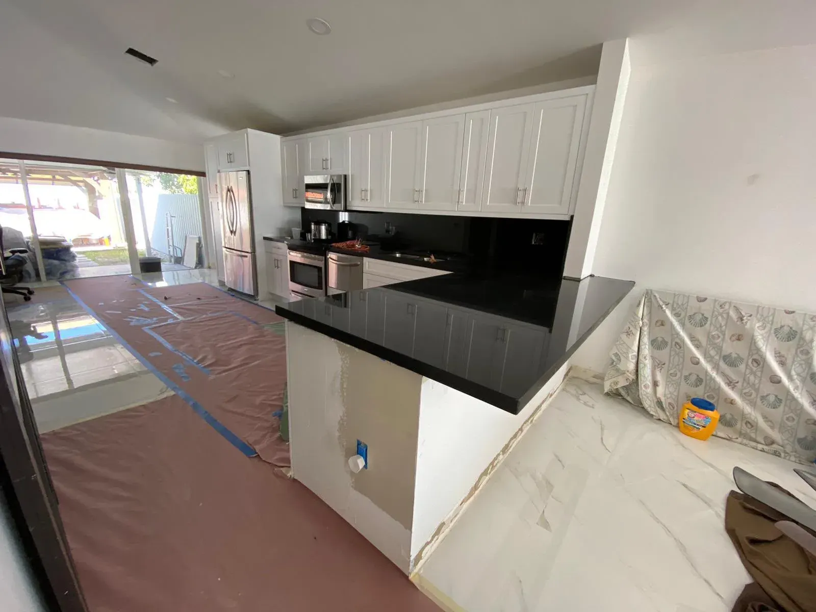 Open kitchen with white cabinets and a black countertop