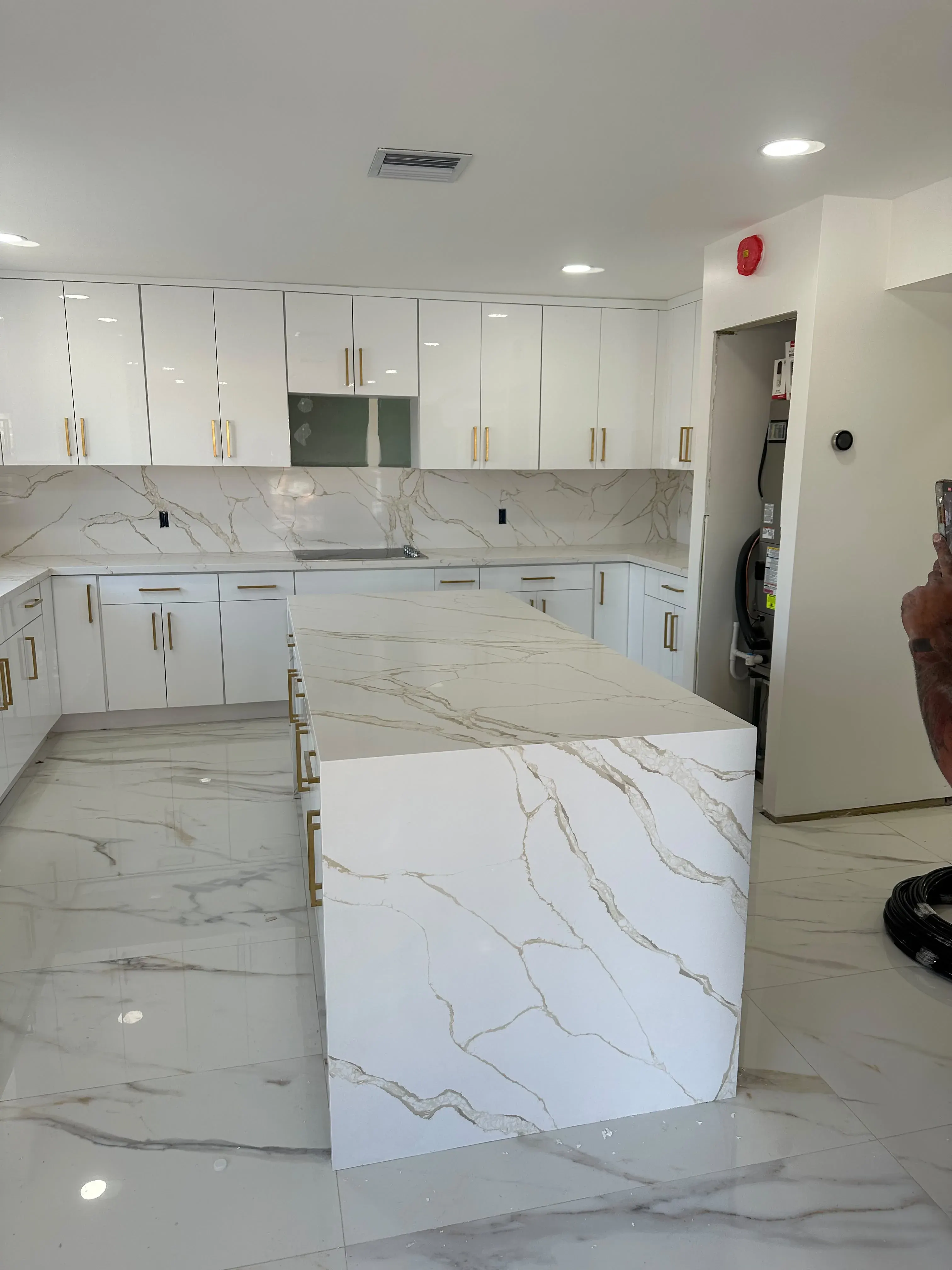 White kitchen with a marble waterfall island
