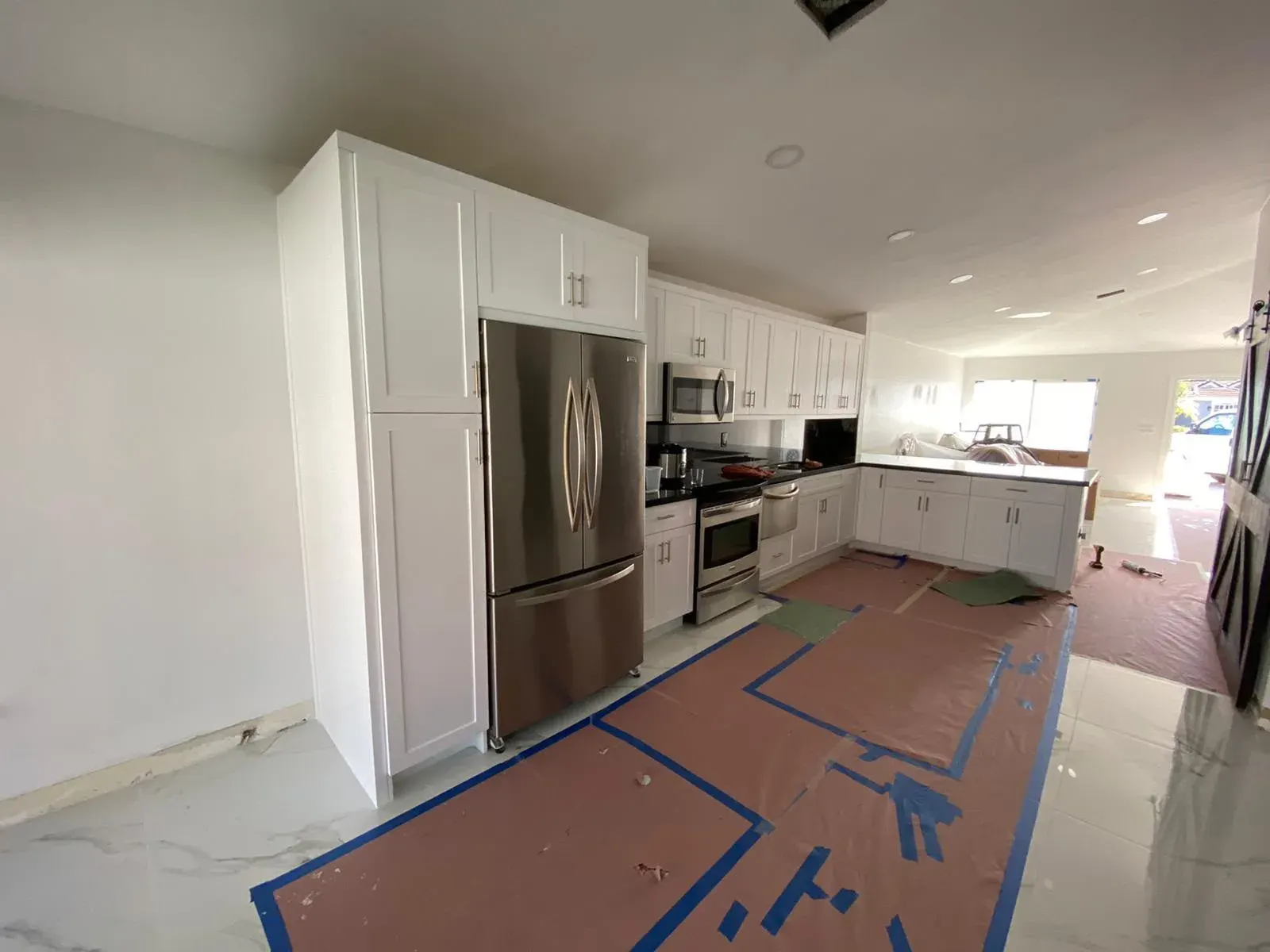White kitchen cabinets with protective floor covering