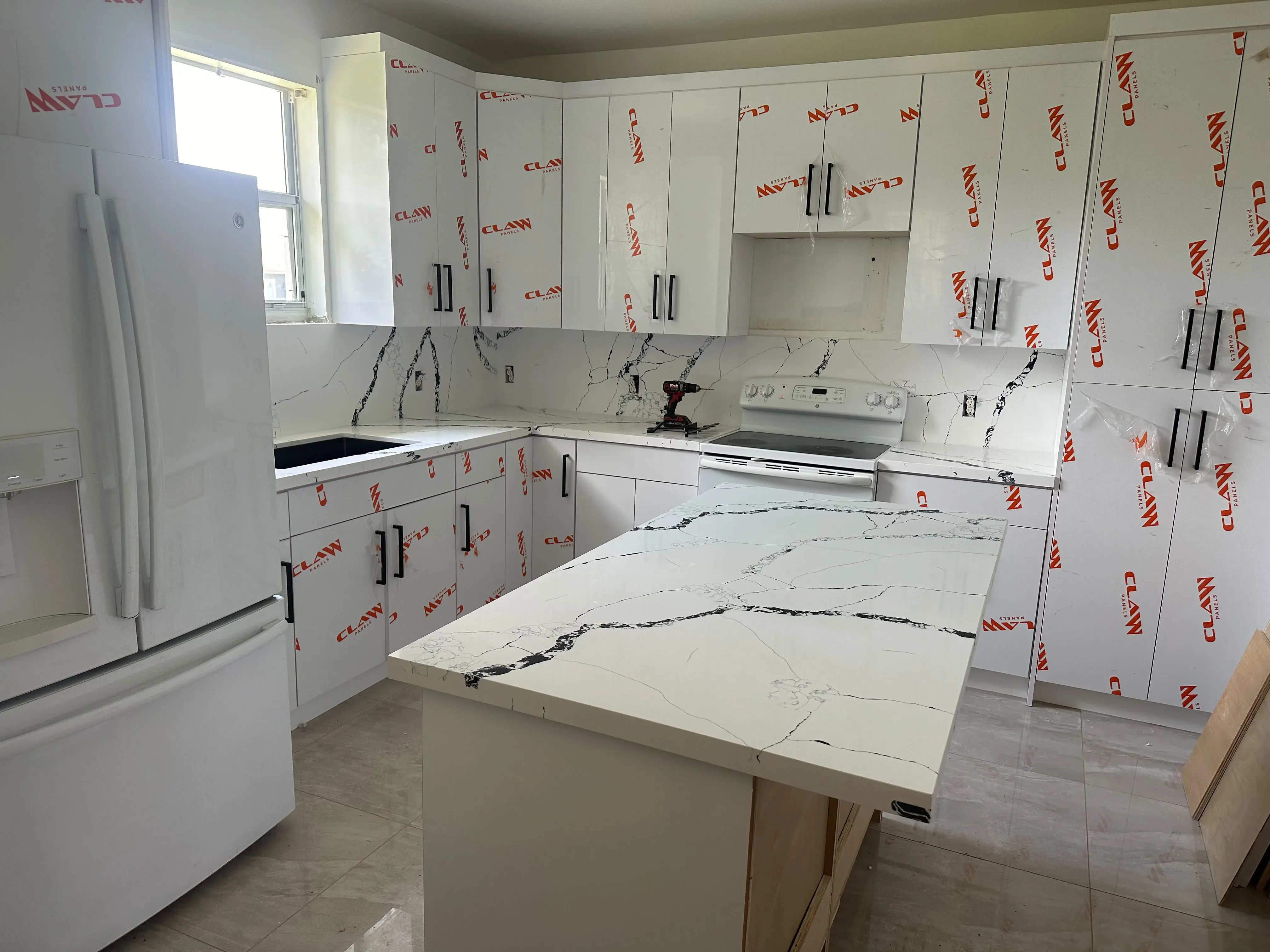 White kitchen cabinets protected for installation