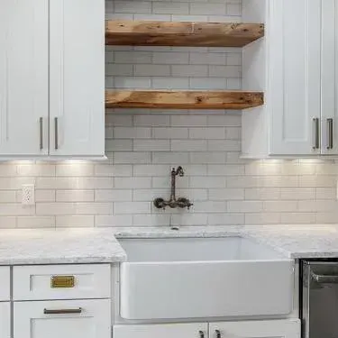 White shaker cabinets with a farmhouse sink and open wood shelves