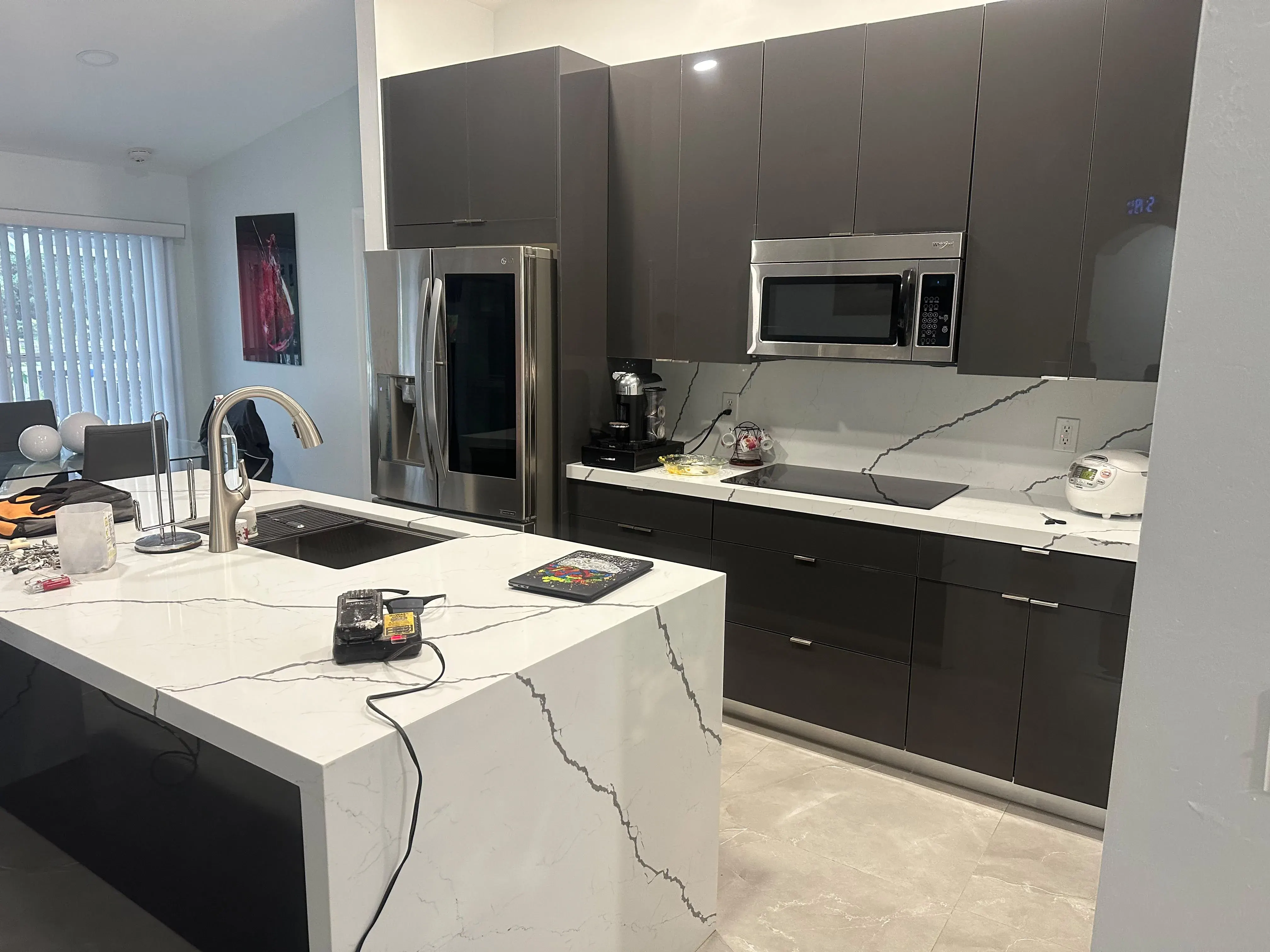 Dark gray cabinets with a marble waterfall island
