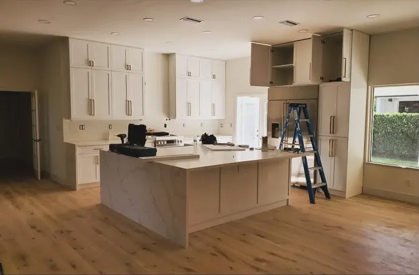 Open kitchen with white cabinets and a wood floor
