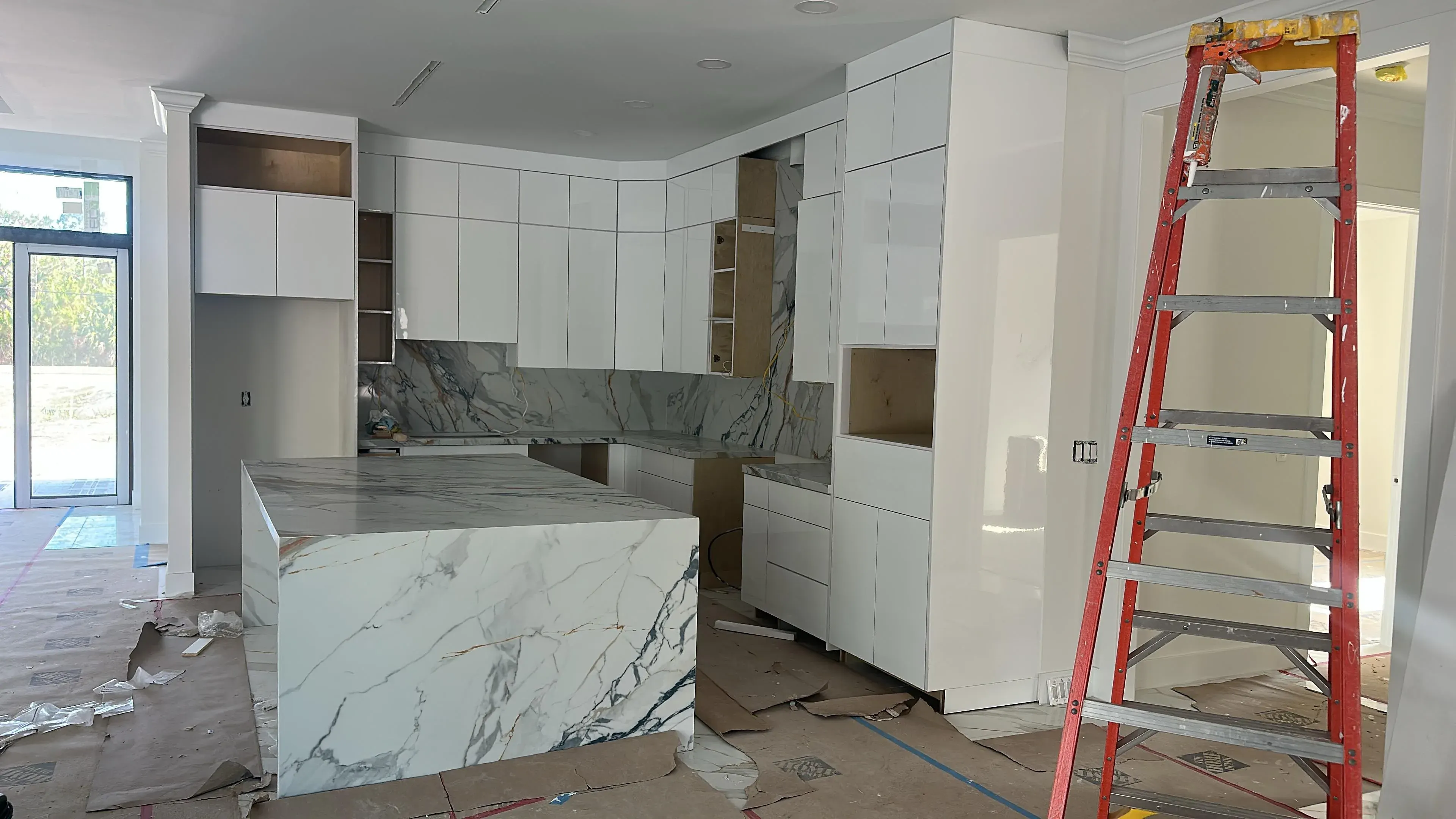 Kitchen with a marble waterfall island and a ladder