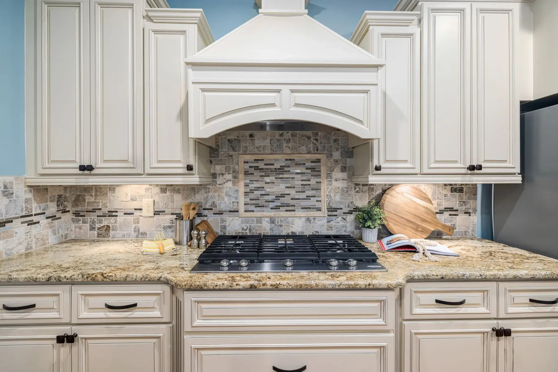 Raised panel kitchen cabinets with a range hood in a Lehigh Acres home