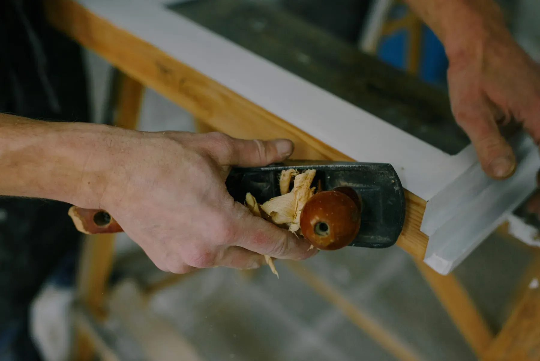 Hand plane shaping white painted trim for a carpentry job near Buckingham, FL