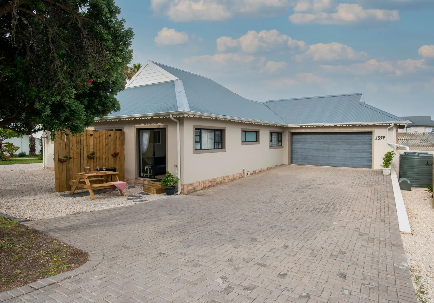 Single-story stucco home with a paver driveway and metal roof in Buckingham, FL