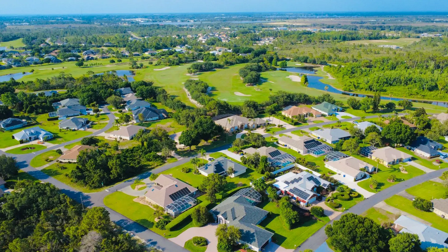 Aerial view of a planned golf community with single-story homes in Estero, FL