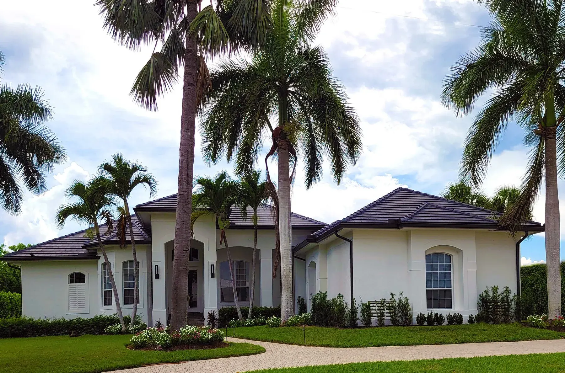 White stucco home with royal palms typical of Fort Myers, FL